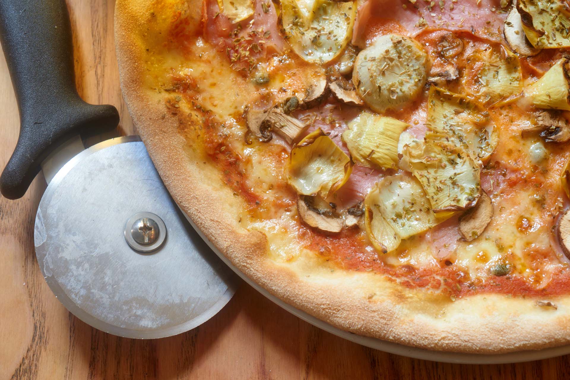 Aerial photo of pizza on a plate with a pizza wheel