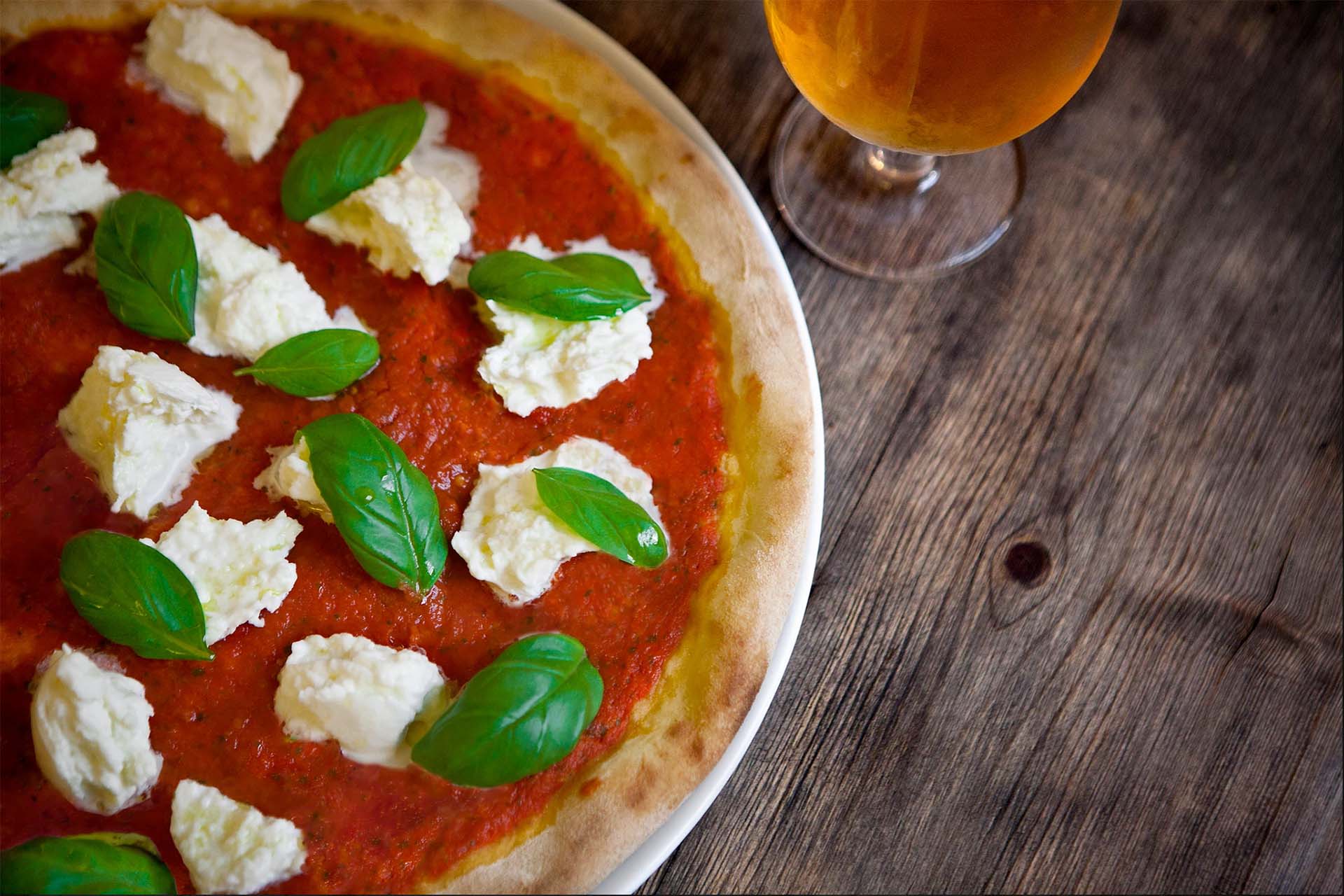 Margarita pizza with glass of beer rest on table